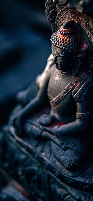 Ancient Buddha Statue in Meditative Pose with Dramatic Dark Lighting HD phone wallpaper