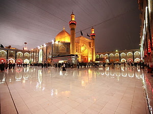 Imam Hussain Shrine in Karbala at Night with Illuminated Minarets and Reflective Courtyard HD wallpaper