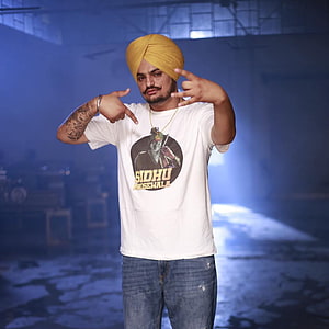 Sidhu Moose Wala in Yellow Turban and White T-Shirt in Industrial Setting HD wallpaper