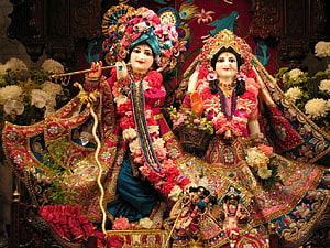 Radha Krishna ISKCON Temple Deities in Ornate Floral Garlands and Traditional Attire HD wallpaper