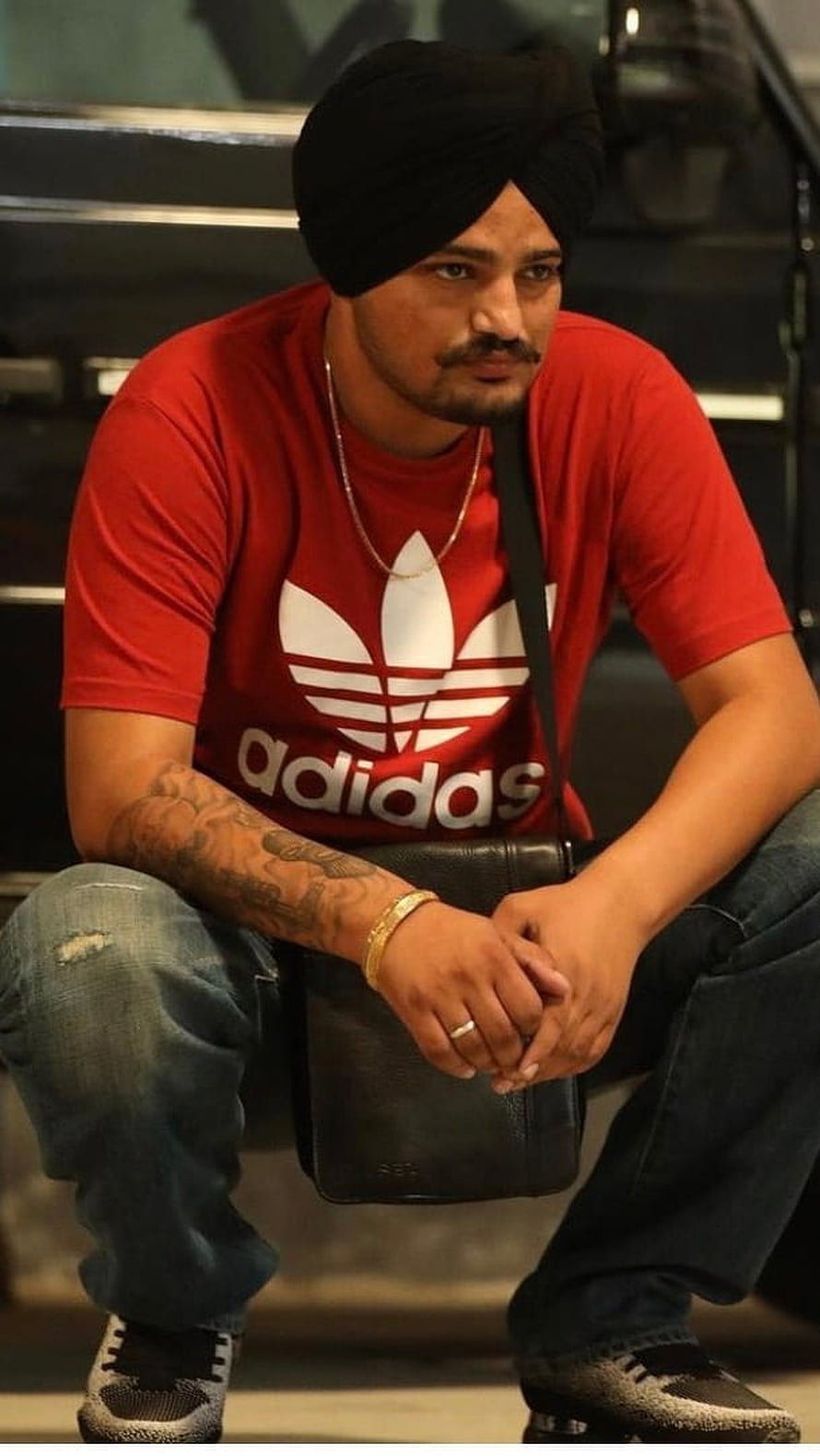 Sidhu Moose Wala in Red Adidas Tee and Black Turban Sitting with Crossbody Bag HD phone wallpaper