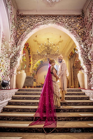 Indian Bride and Groom in Traditional Attire at an Ornate Floral Wedding Venue HD phone wallpaper