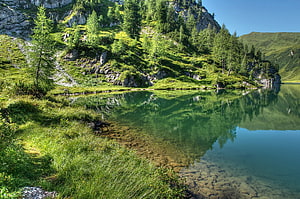 Serene Alpine Lake with Crystal Clear Waters and Lush Green Forested Hills HD wallpaper