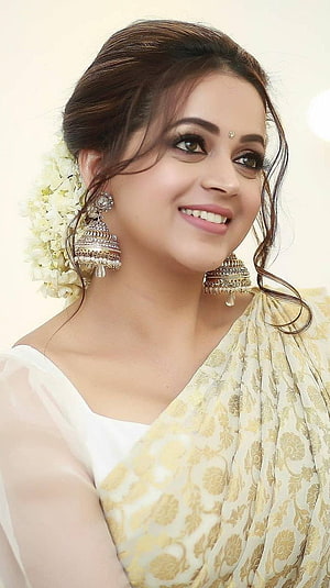 Bhavana in a cream and gold brocade saree with traditional jhumka earrings and floral hair accessory HD phone wallpaper