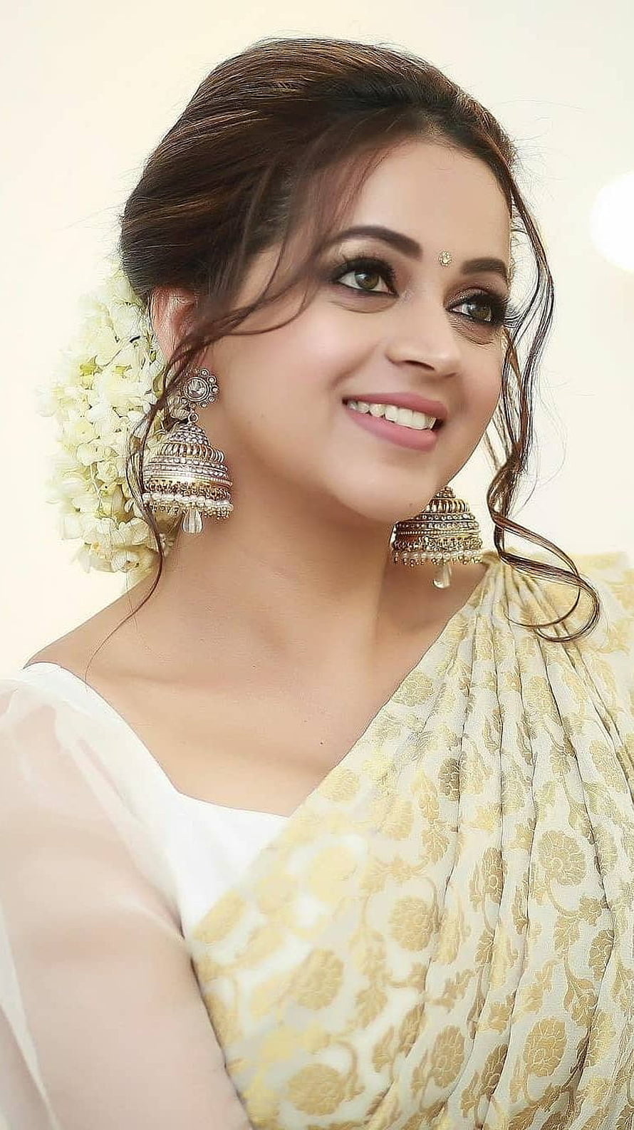 Bhavana in a cream and gold brocade saree with traditional jhumka earrings and floral hair accessory HD phone wallpaper