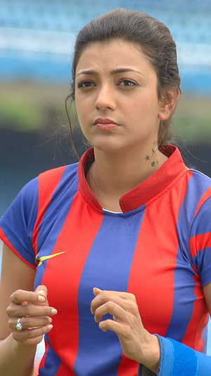 Kajal Agarwal in a red and blue striped sports jersey with a serious expression HD phone wallpaper