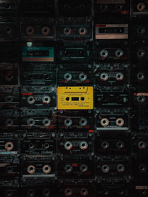 Grid of Vintage Audio Cassette Tapes with One Bright Yellow Shell HD phone wallpaper