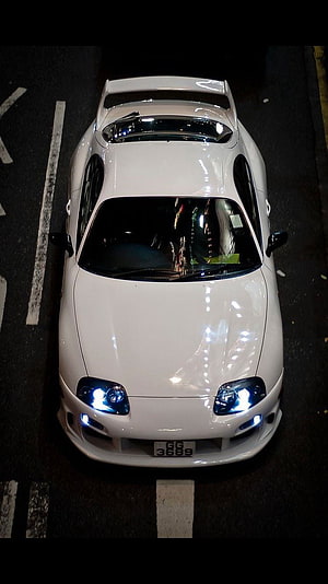 Top-Down View of a White Toyota Supra Parked on a Street at Night with Blue Headlights HD phone wallpaper