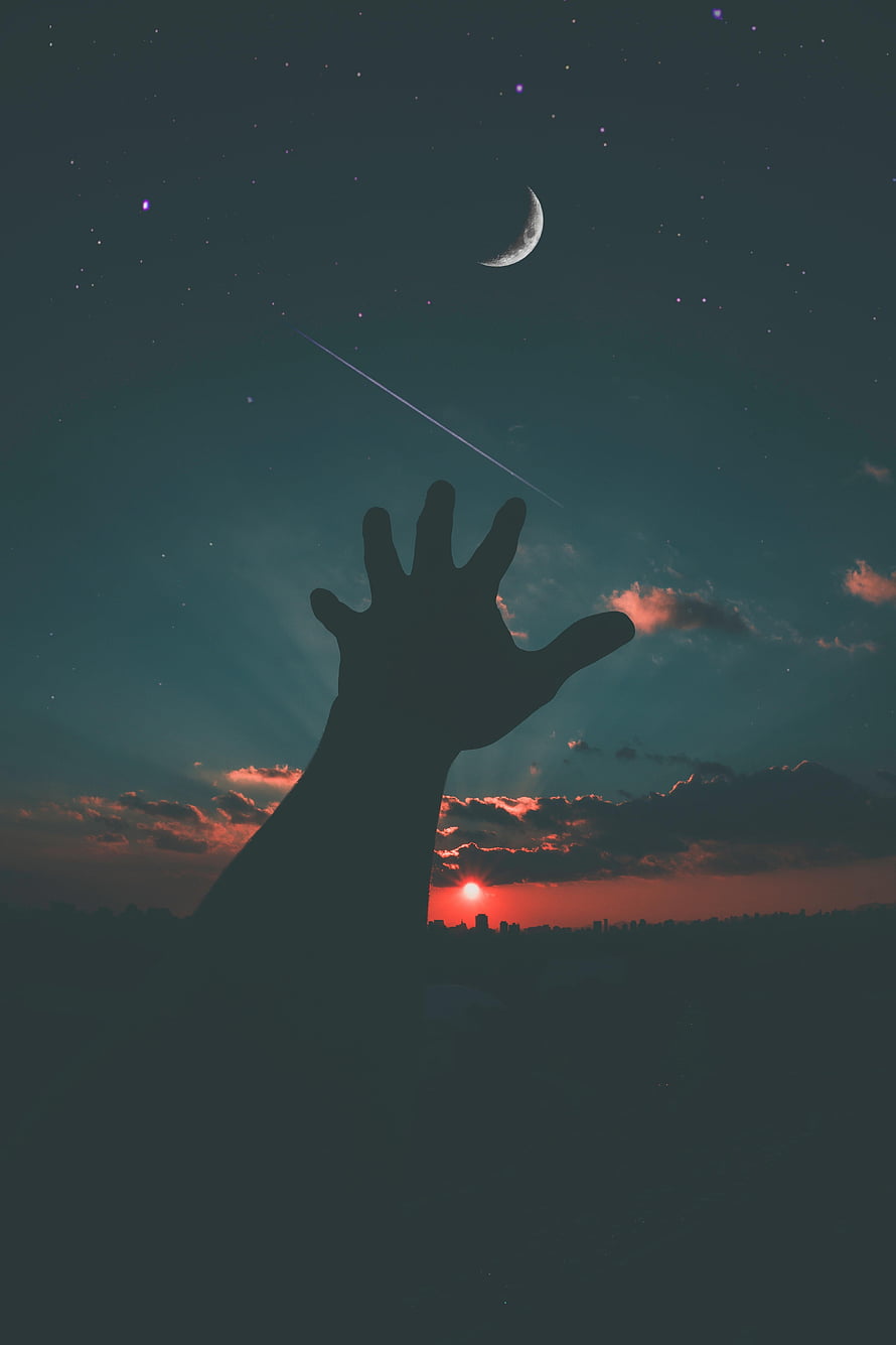 Silhouette of a hand reaching toward a crescent moon and shooting star in a twilight sky HD phone wallpaper