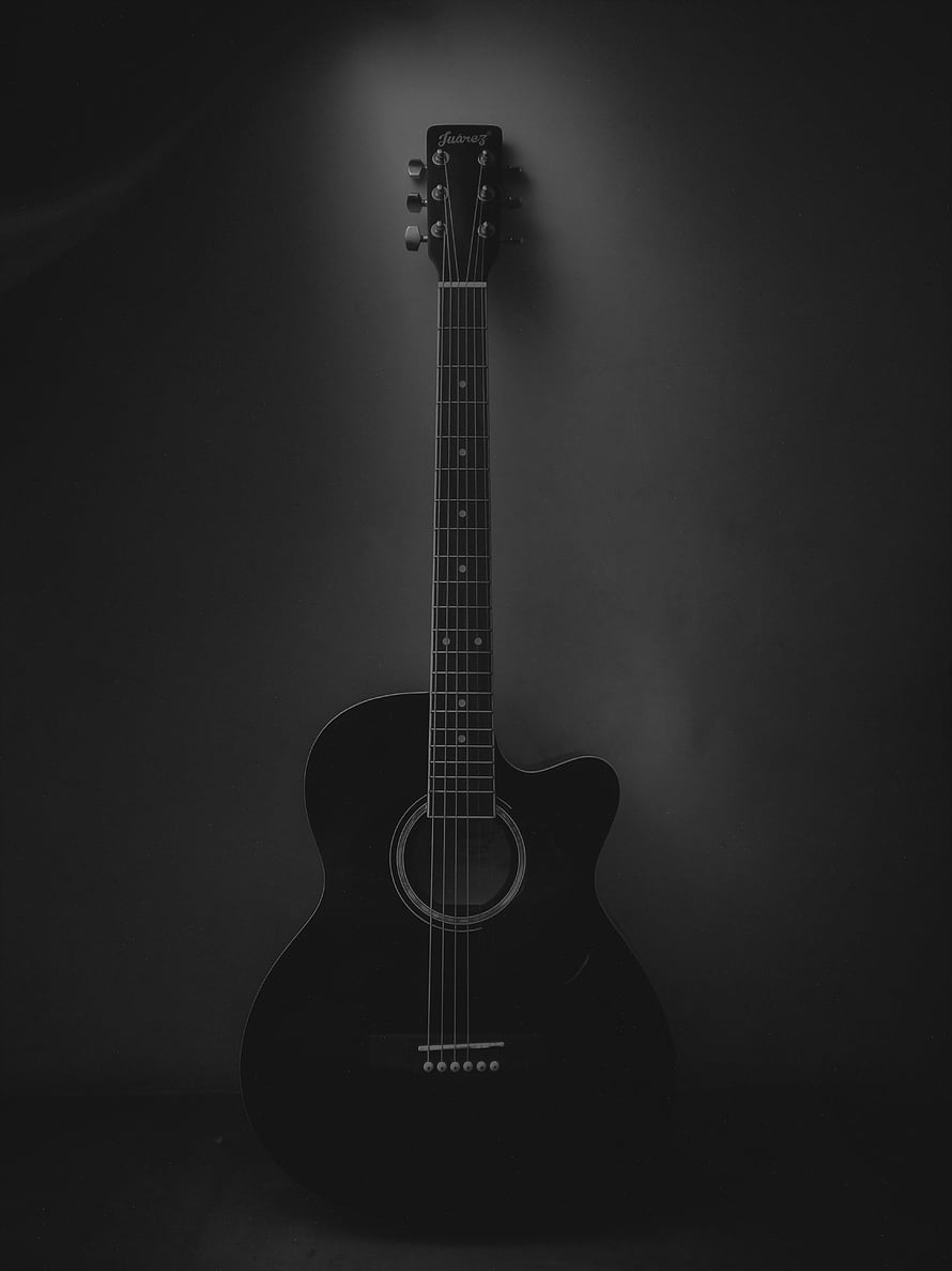 Black Acoustic Guitar with Cutaway Body Against Dark Studio Background HD phone wallpaper