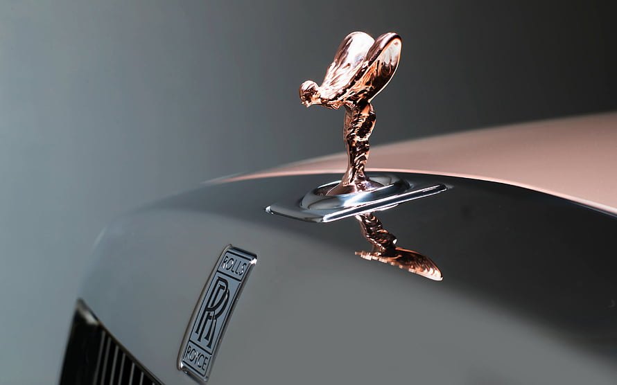 Close-up of the Rolls-Royce Spirit of Ecstasy hood ornament and emblem on a luxury car HD wallpaper