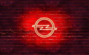 Glowing red Opel neon emblem mounted on a dark textured brick wall HD wallpaper