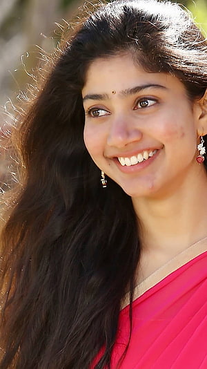 Sai Pallavi smiling portrait in a pink sari with long dark hair and gold earrings HD phone wallpaper