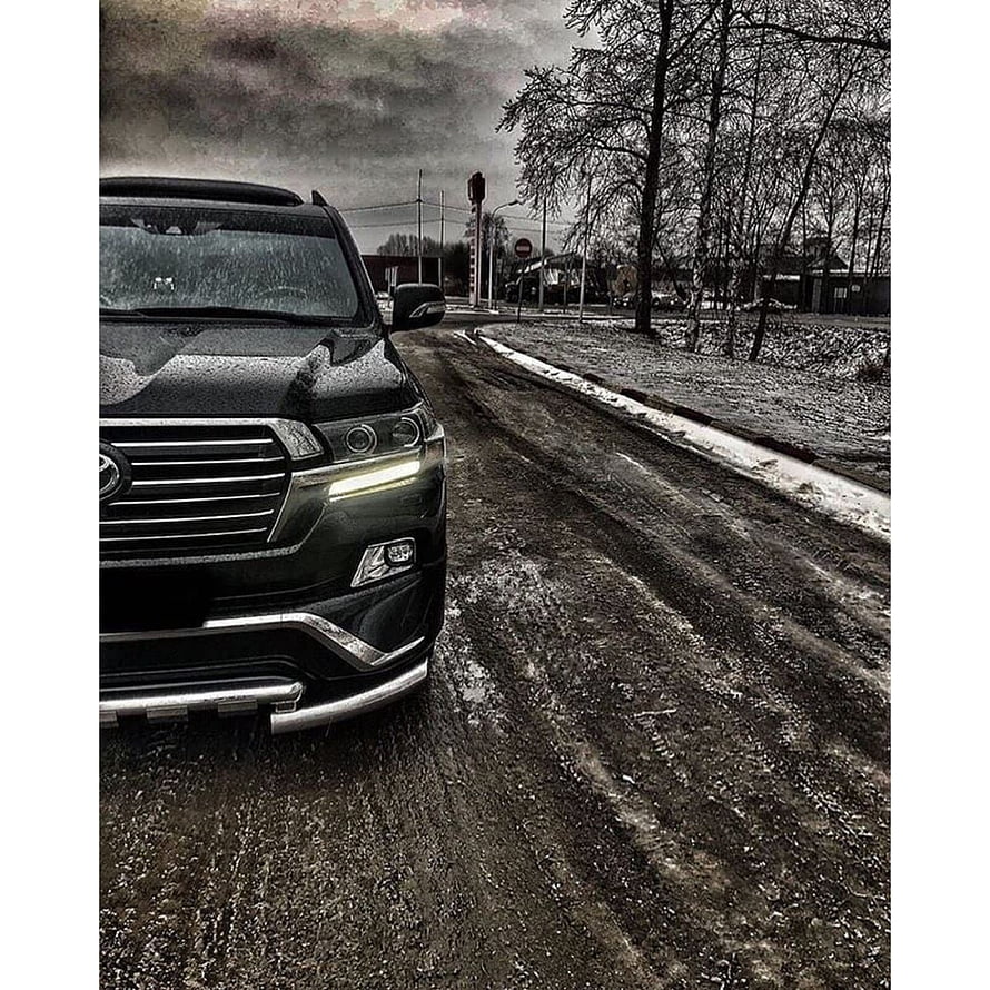 Black Toyota Land Cruiser ZX on a wet gravel road under a moody overcast sky HD phone wallpaper