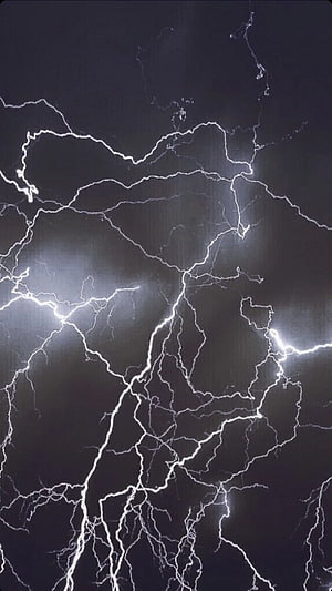 Dramatic branching lightning bolts striking through a dark stormy night sky HD phone wallpaper