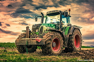 Fendt 820 Tractor in a Field Under Dramatic Sunset Sky HD wallpaper