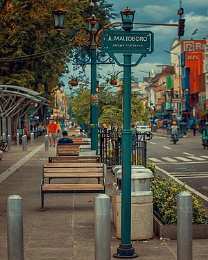 Malioboro Street in Yogyakarta, Indonesia with ornate green lamp posts and wooden benches HD phone wallpaper