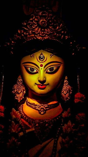 Durga Maa Shrine Idol with Ornate Crown and Traditional Jewelry in Warm Candlelight HD phone wallpaper