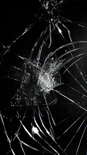 Shattered Glass Texture with Radiating Cracks on a Dark Background HD phone wallpaper