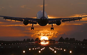 Commercial Jetliner Silhouetted Against Dramatic Sunset During Final Approach HD wallpaper
