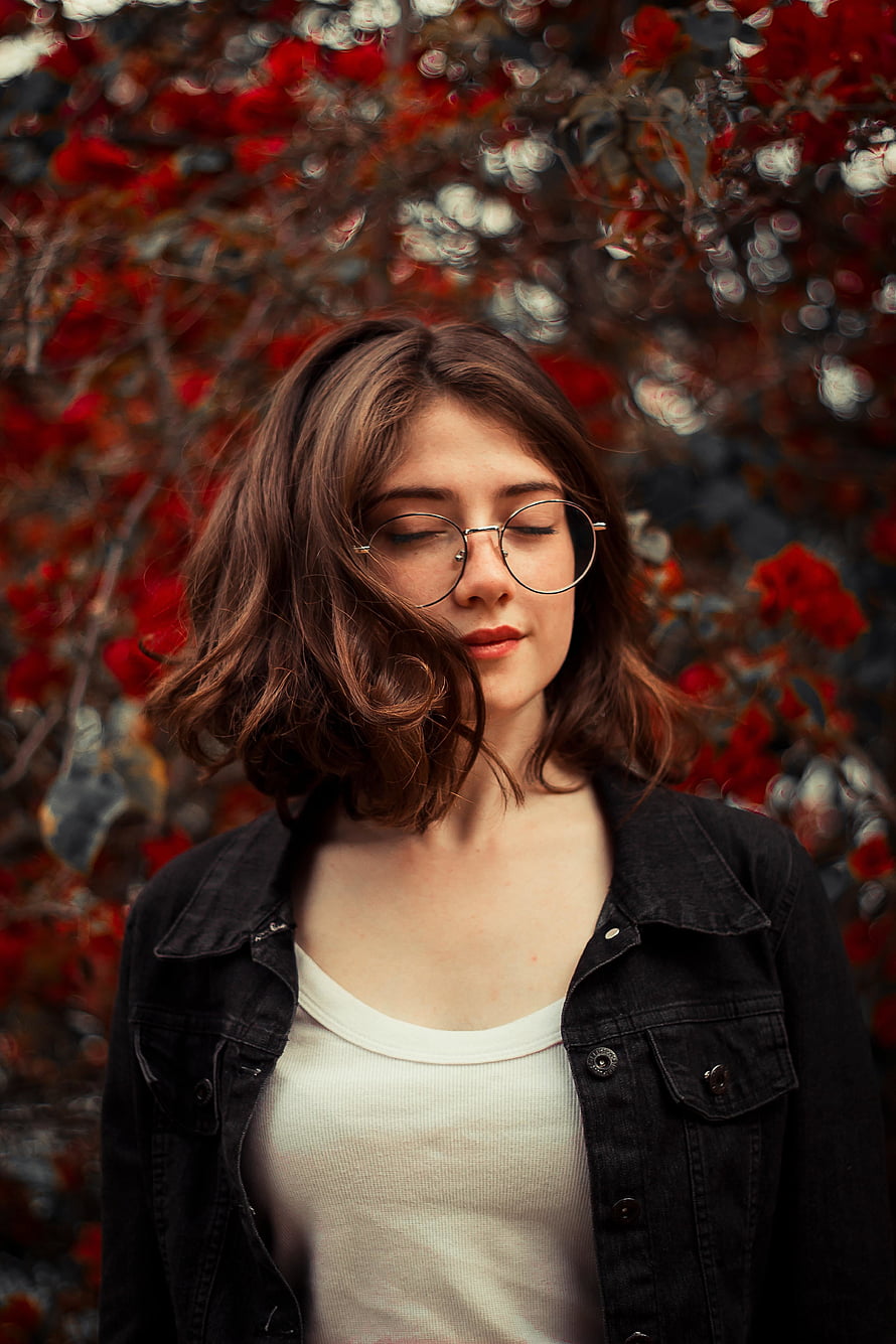 Serene Portrait of Young Woman With Round Glasses Against Vibrant Red Floral Background, Close eyes, cute, girl model HD phone wallpaper