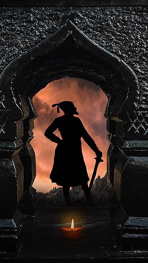 Shivaji Maharaj Silhouette in Stone Archway with Candlelight and Dramatic Sky HD phone wallpaper