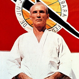 Helio Gracie in White Gi Seated Before Brazilian Jiu Jitsu Federation Emblem HD phone wallpaper