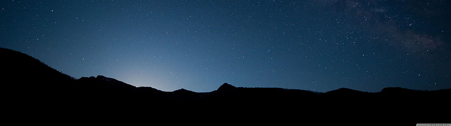 Starry Night Sky Over Mountain Silhouette With Faint Milky Way Glow HD wallpaper