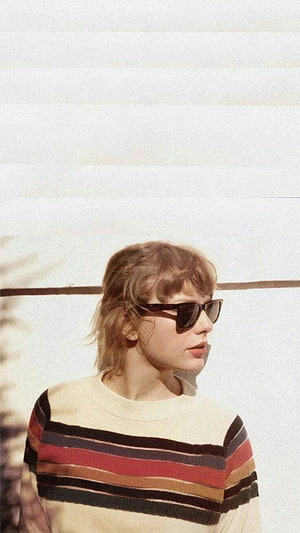 Taylor Swift in striped sweater and sunglasses against a bright white wall HD phone wallpaper