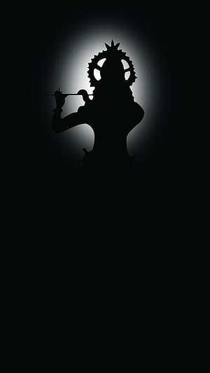 Dark Krishna Silhouette with Flute and Crown in Dramatic Backlight HD phone wallpaper