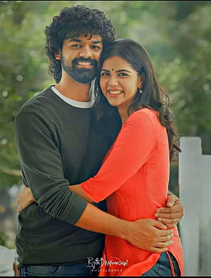 Hridayam Movie Still: Couple Embracing in a Lush Green Outdoor Setting HD phone wallpaper