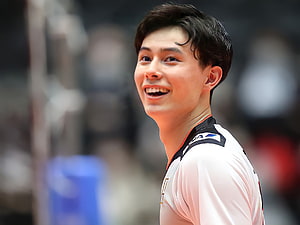 Ran Takahashi smiling in white basketball jersey with black collar and orange trim on the court HD wallpaper