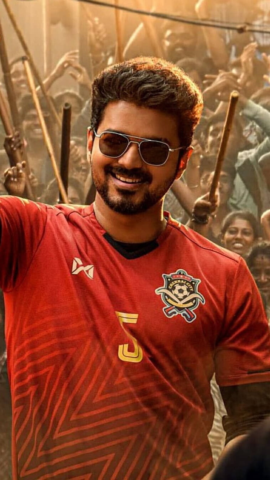 Vijay in red Chennai FC jersey with sunglasses and beaming smile amid cheering crowd HD phone wallpaper