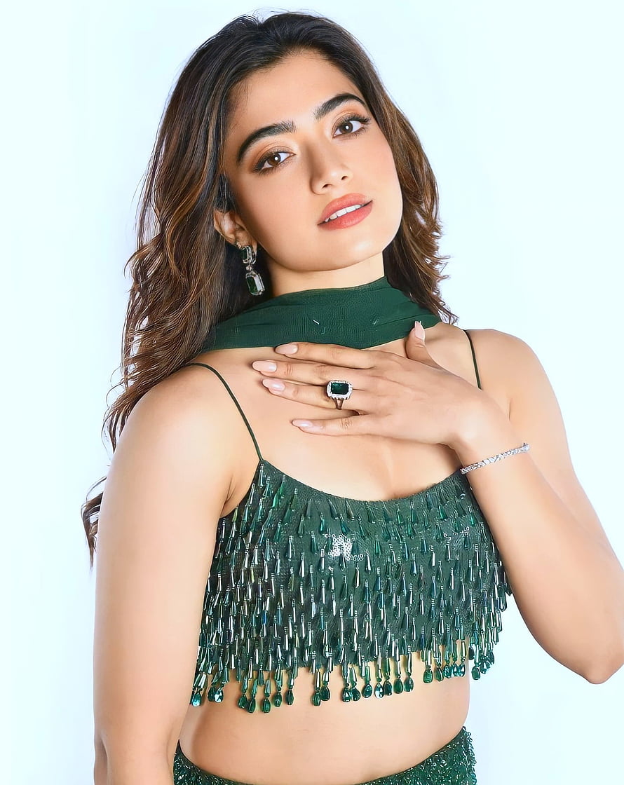 Rashmika Mandanna in an emerald green beaded crop top with matching jewelry and a soft studio backdrop HD phone wallpaper