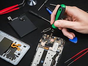 Smartphone Internal Repair with Precision Tools and Circuit Board HD wallpaper