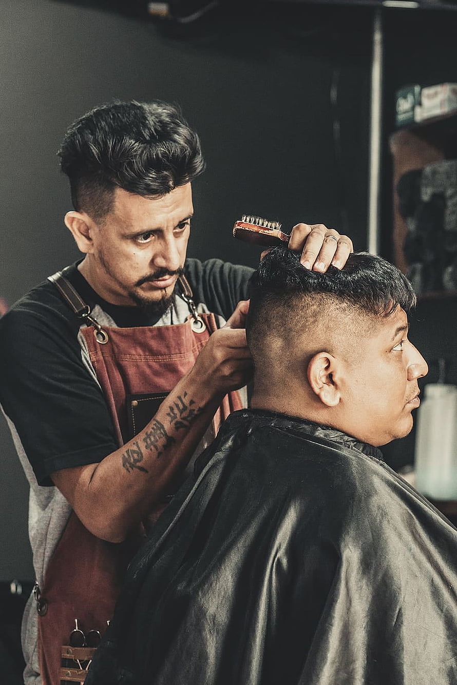 Barber Styling a Man's Hair in a Modern Barbershop HD phone wallpaper