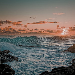 Dramatic Ocean Sunset with Crashing Waves and Rocky Shoreline HD phone wallpaper