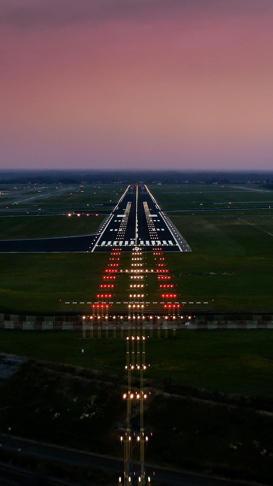 Aerial View of Illuminated Airport Runway at Dusk with Red and White Lights HD phone wallpaper