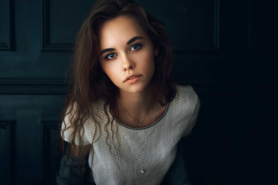 Moody Portrait of a Young Woman with Wavy Brown Hair and Blue Eyes HD wallpaper