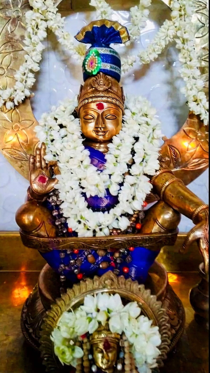 Ayyappa deity statue adorned with white jasmine garlands and traditional blue attire HD phone wallpaper