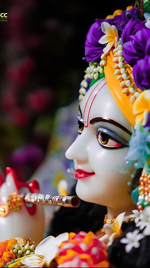 Close-up of Krishna idol with flute and floral crown HD phone wallpaper