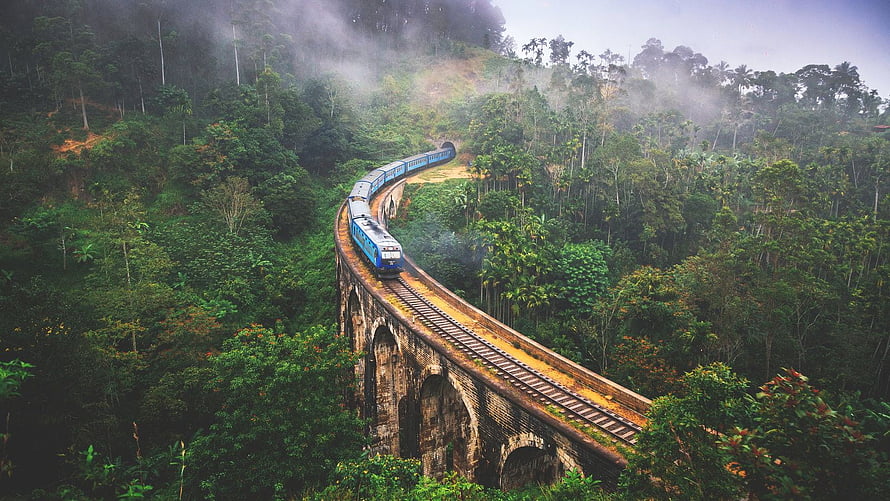 Blue Train Crossing a Historic Stone Viaduct in the Misty Hills of Kandy, Sri Lanka HD wallpaper