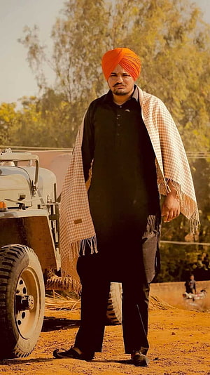 Sidhu Moose Wala in Traditional Punjabi Attire Standing in a Rural Village Setting HD phone wallpaper
