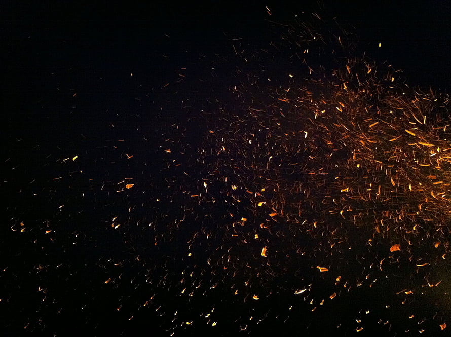 Glowing Fire Sparks and Embers Scattering Against a Deep Black Night Sky HD wallpaper