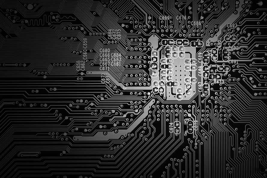 Black and White Close-Up of a Complex Printed Circuit Board with Integrated Chip HD wallpaper