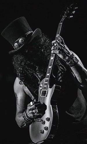Slash from Guns N' Roses playing electric guitar in a black and white portrait HD phone wallpaper