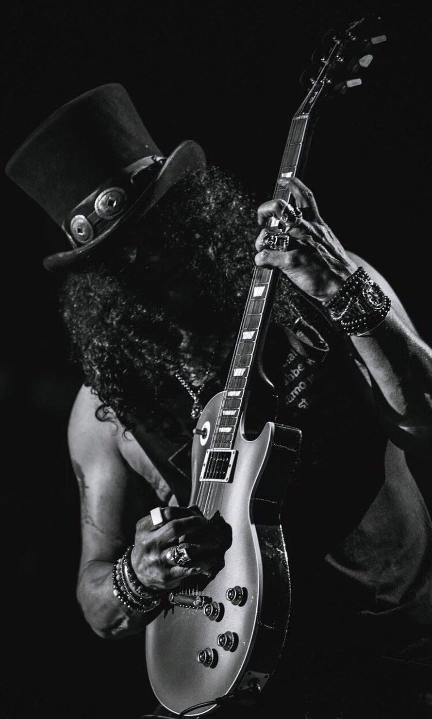 Slash from Guns N' Roses playing electric guitar in a black and white portrait HD phone wallpaper