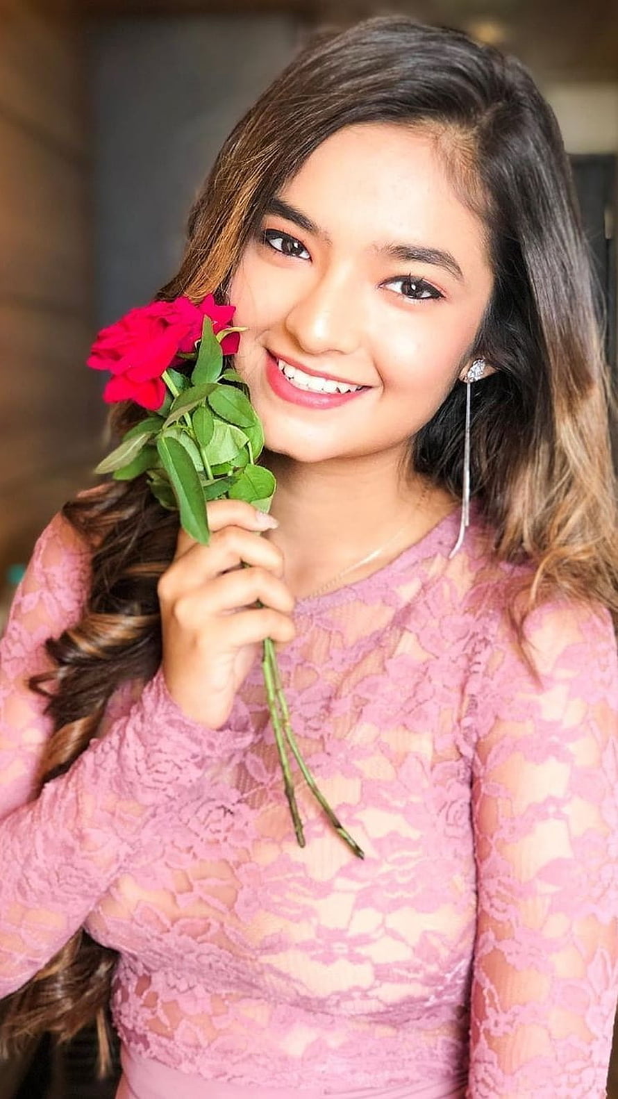 Anushka Sen smiling portrait holding red roses in a pink lace top HD phone wallpaper