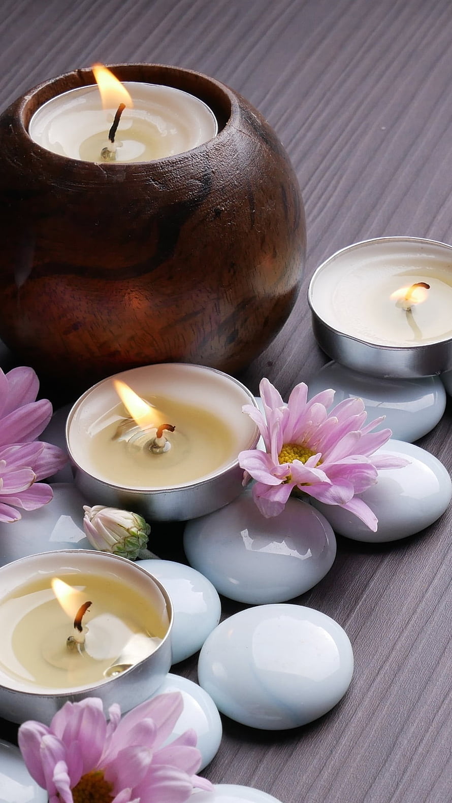 Relaxing Spa Scene With Lit Candles, Pink Chrysanthemums, And Smooth White Stones HD phone wallpaper