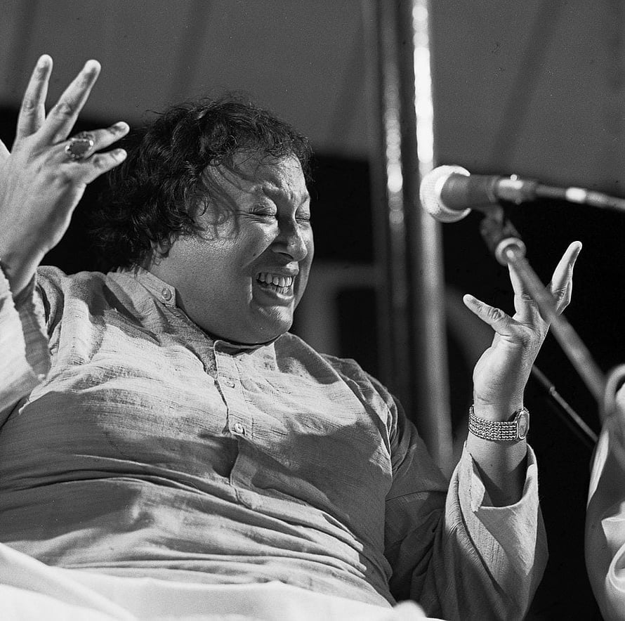 Nusrat Fateh Ali Khan performing with expressive hand gestures in black and white HD wallpaper